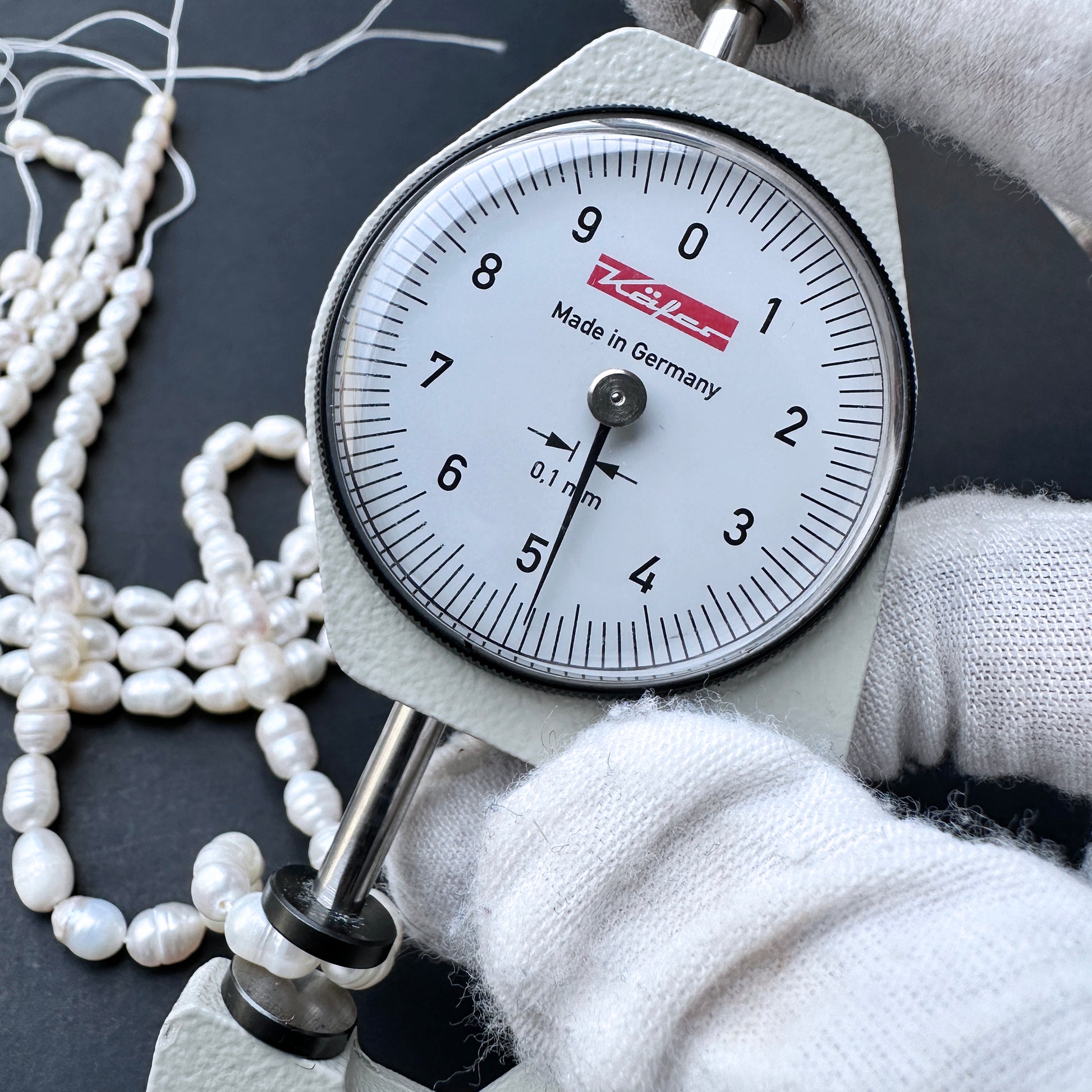 A dial gauge measures a baroque rice shaped Freshwater Pearl.