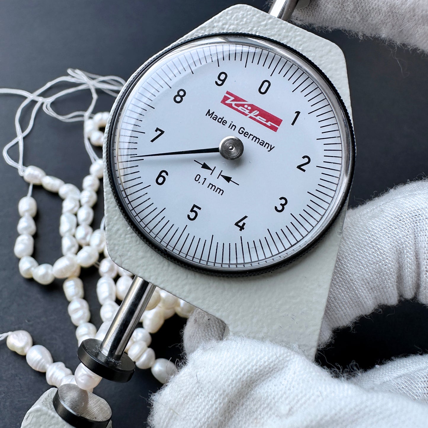 A dial gauge measures a baroque rice shaped Freshwater Pearl.