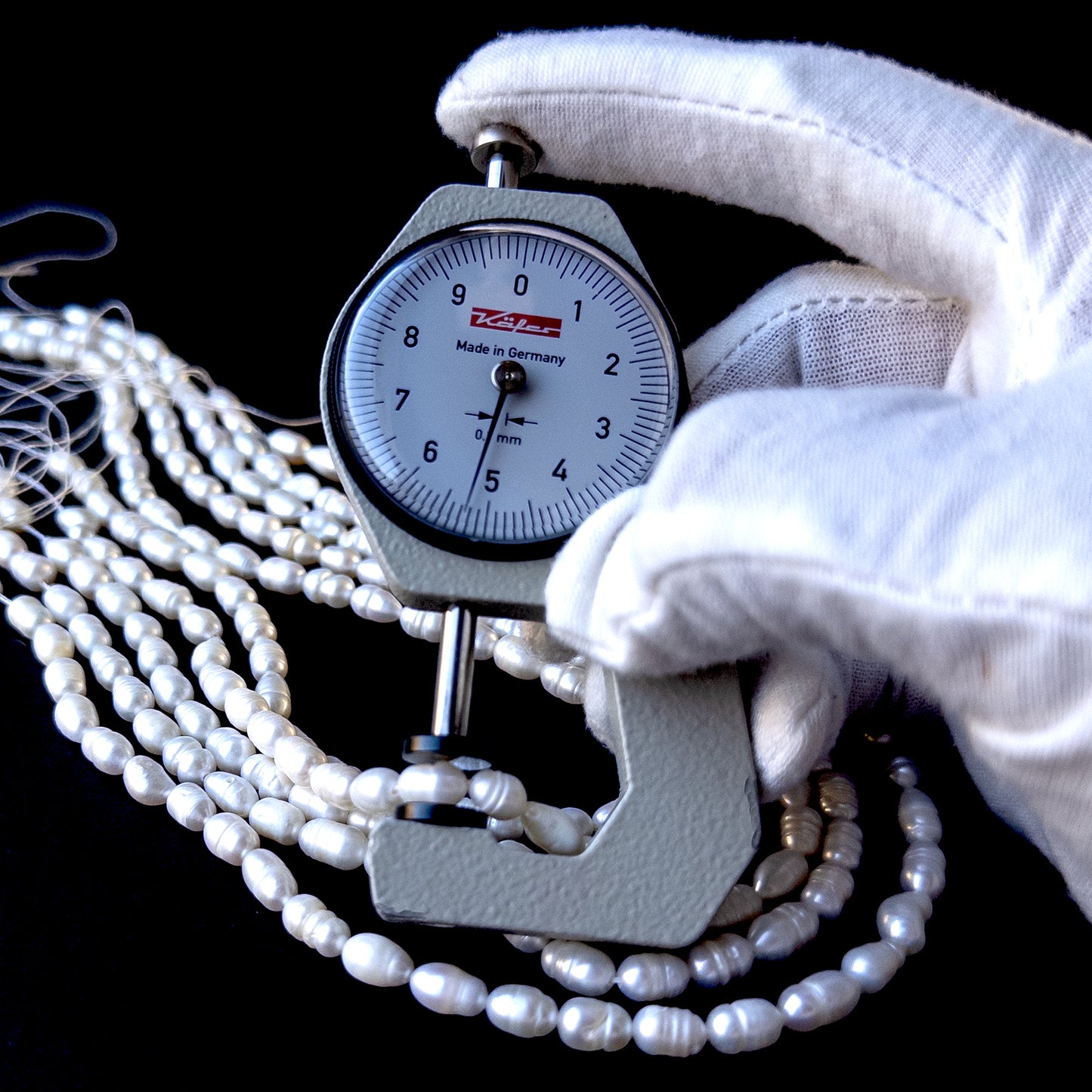A dial gauge measures the freshwater baroque rice‑shaped 7.5–8.5mm x 5mm pearl.
