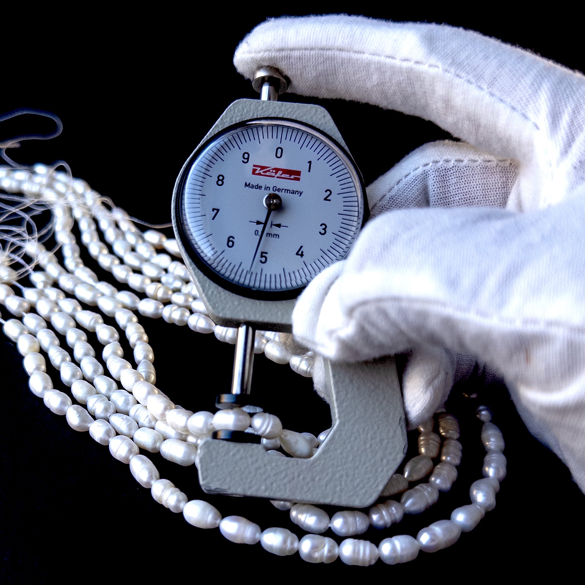 A dial gauge measures the freshwater baroque rice‑shaped 7.5–8.5mm x 5mm pearl.
