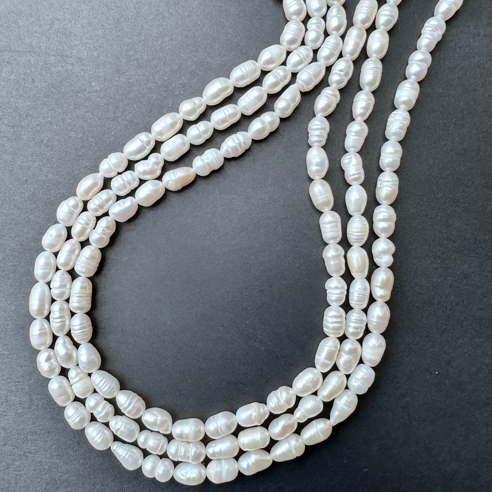 Freshwater Pearls in baroque rice shapes with soft lustre arranged on a 34cm strand for jewellery making.
