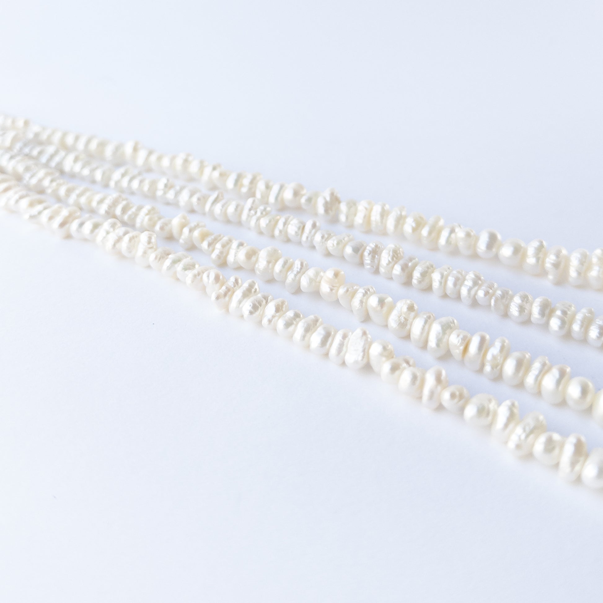 Freshwater Baroque pearl beads arranged in a lustrous white strand for DIY jewellery making.