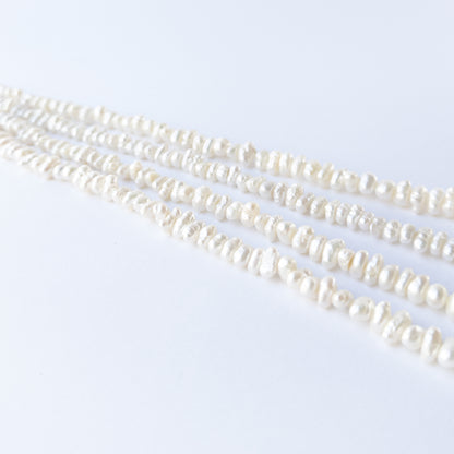 Freshwater Baroque pearl beads arranged in a lustrous white strand for DIY jewellery making.