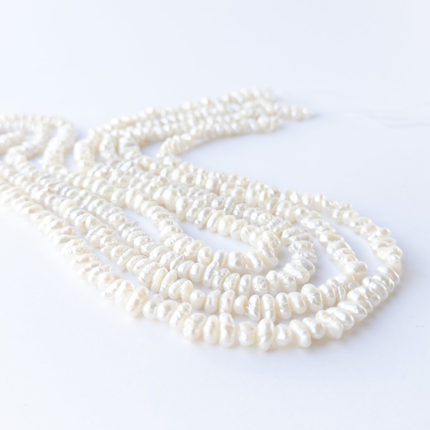 Freshwater Baroque pearl beads arranged in a lustrous white strand for DIY jewellery making.