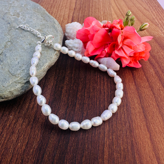 Natural gemstone beads bracelet featuring lustrous 4.5mm Freshwater Pearls in oval cut. Elegant stone beads bracelet with polished Freshwater Pearls and adjustable clasp. Handcrafted Freshwater Pearl bracelet showcasing smooth oval beads and radiant shine.