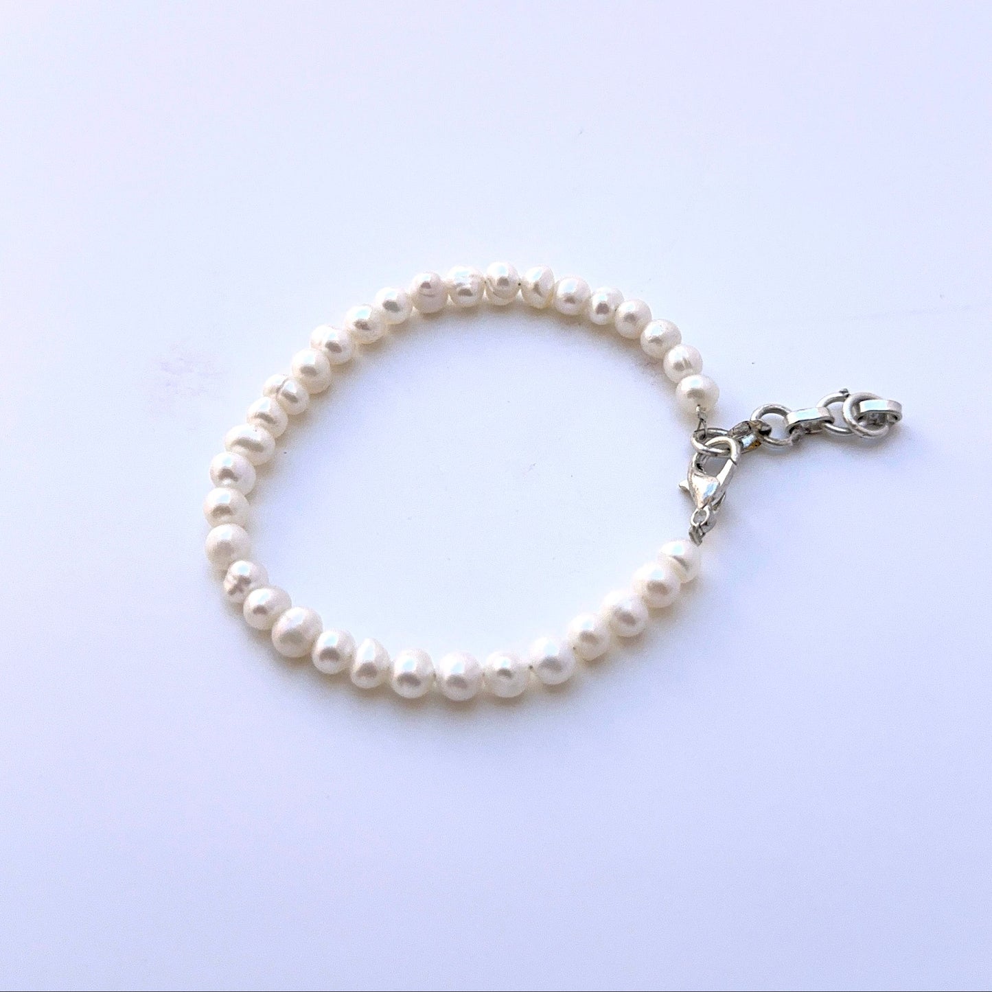 Close‑up of smooth rondelle freshwater pearls arranged on a polished bracelet.