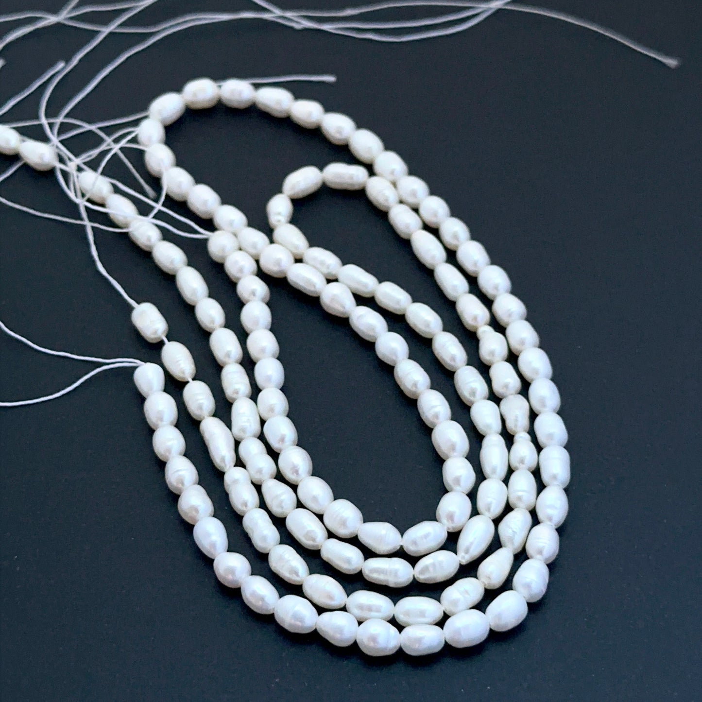 Freshwater oval fancy pearls aligned on a strand highlighting organic shapes, creamy tones and elegant lustre.