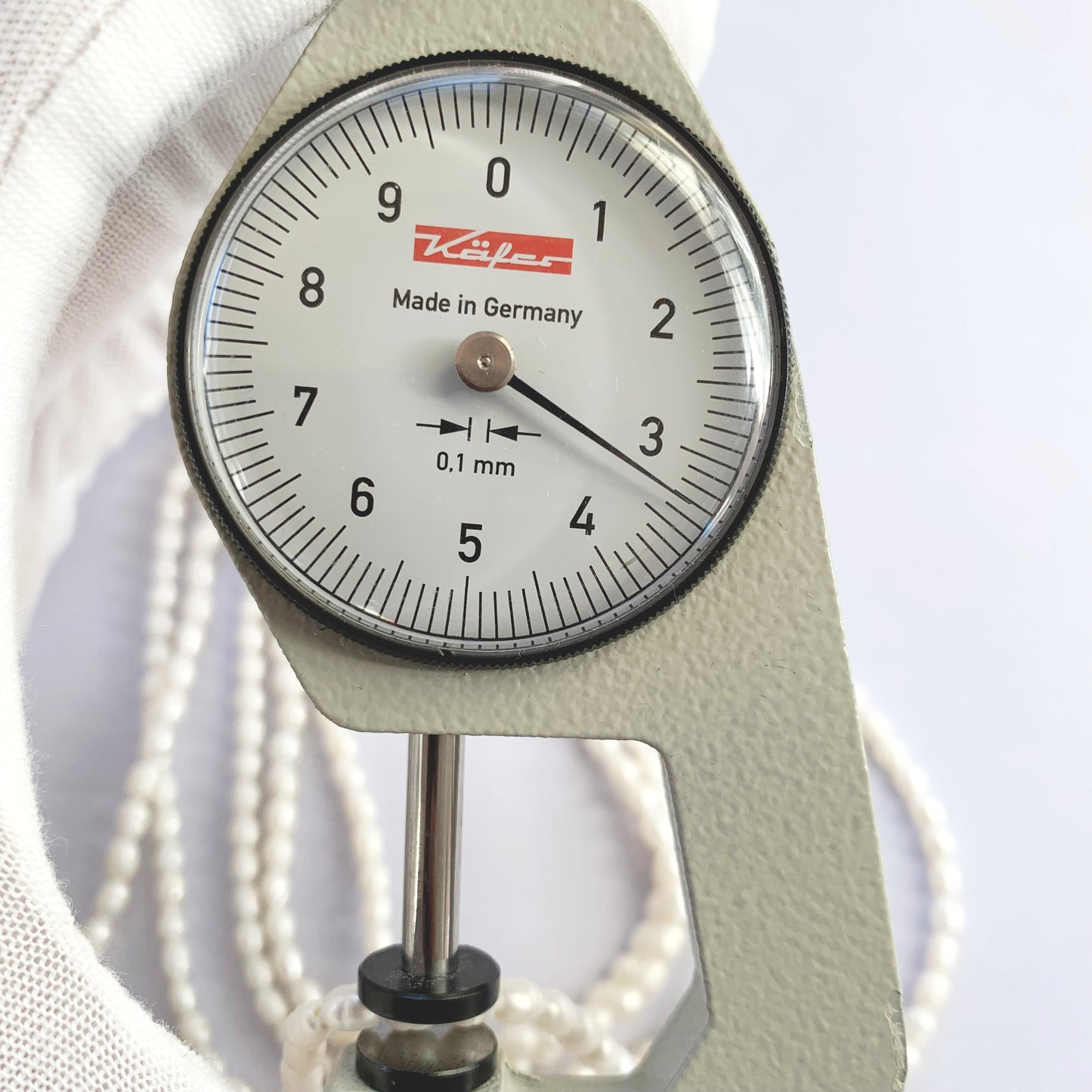 A dial gauge measures the Freshwater Pearl rice cut 3.0-3.3mm gemstone.