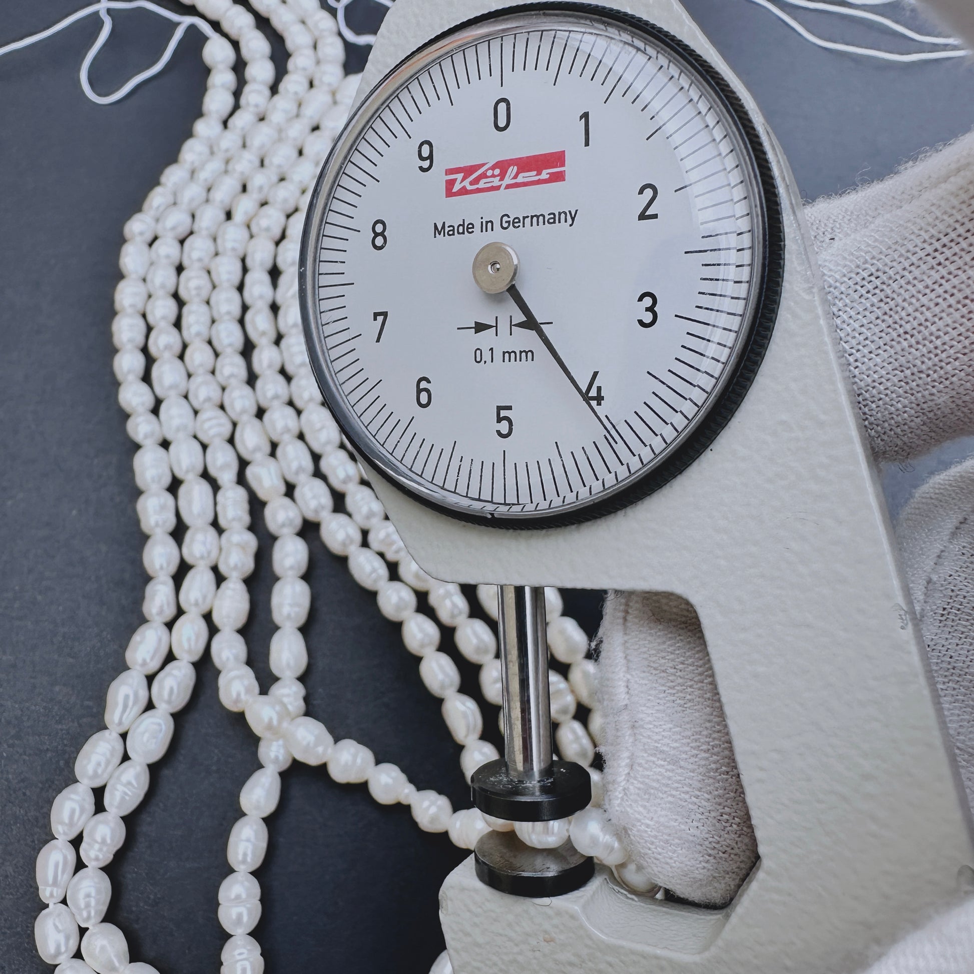 A dial gauge measures the Freshwater Pearl rice shaped 3.9-4.3mm gemstone.