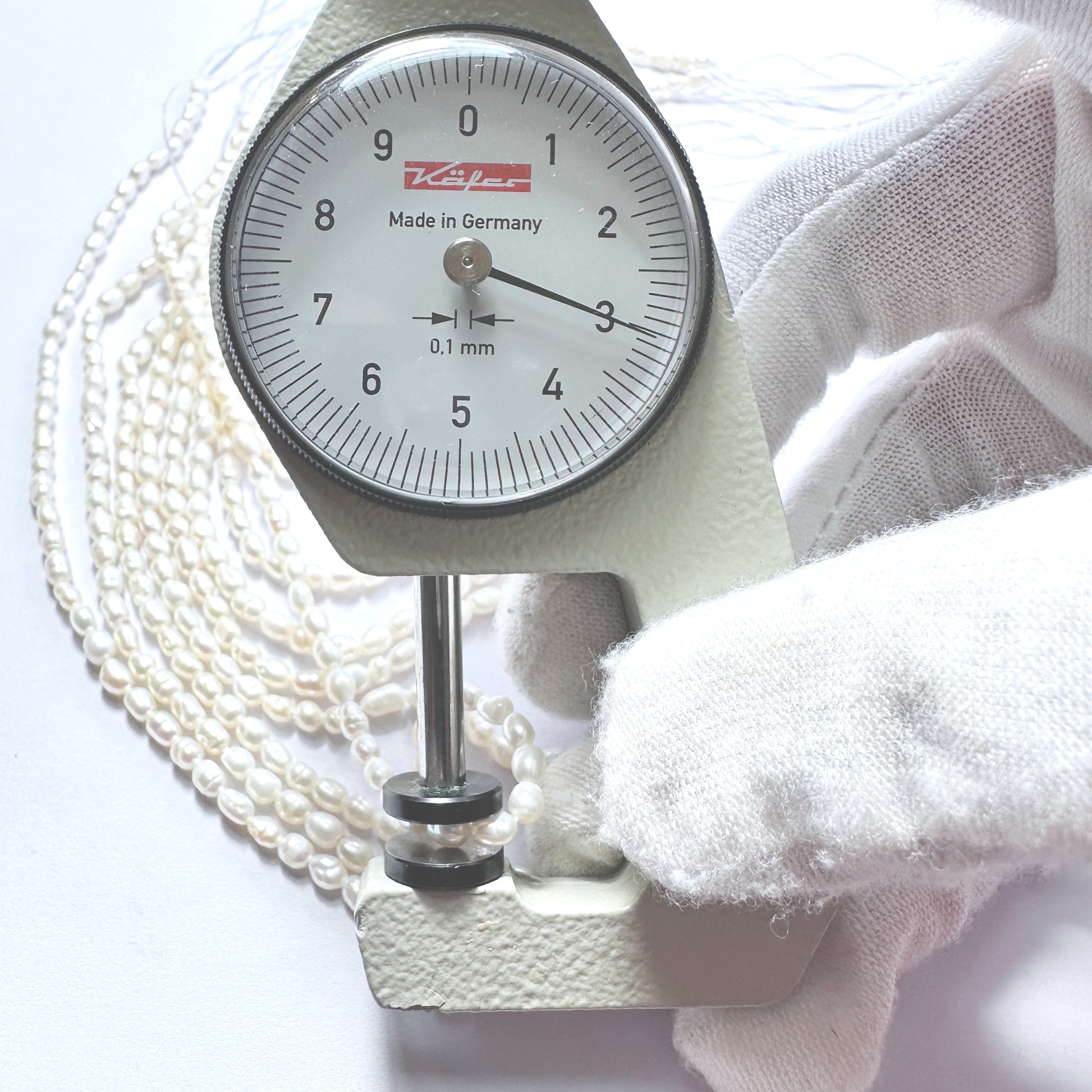 A dial gauge measures the Freshwater Pearl rice cut 3mm gemstone.
