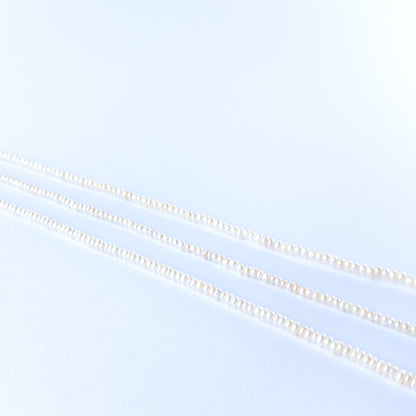 Natural Freshwater Pearl beads arranged in a strand, highlighting their rondelle cut and soft shimmering tones.