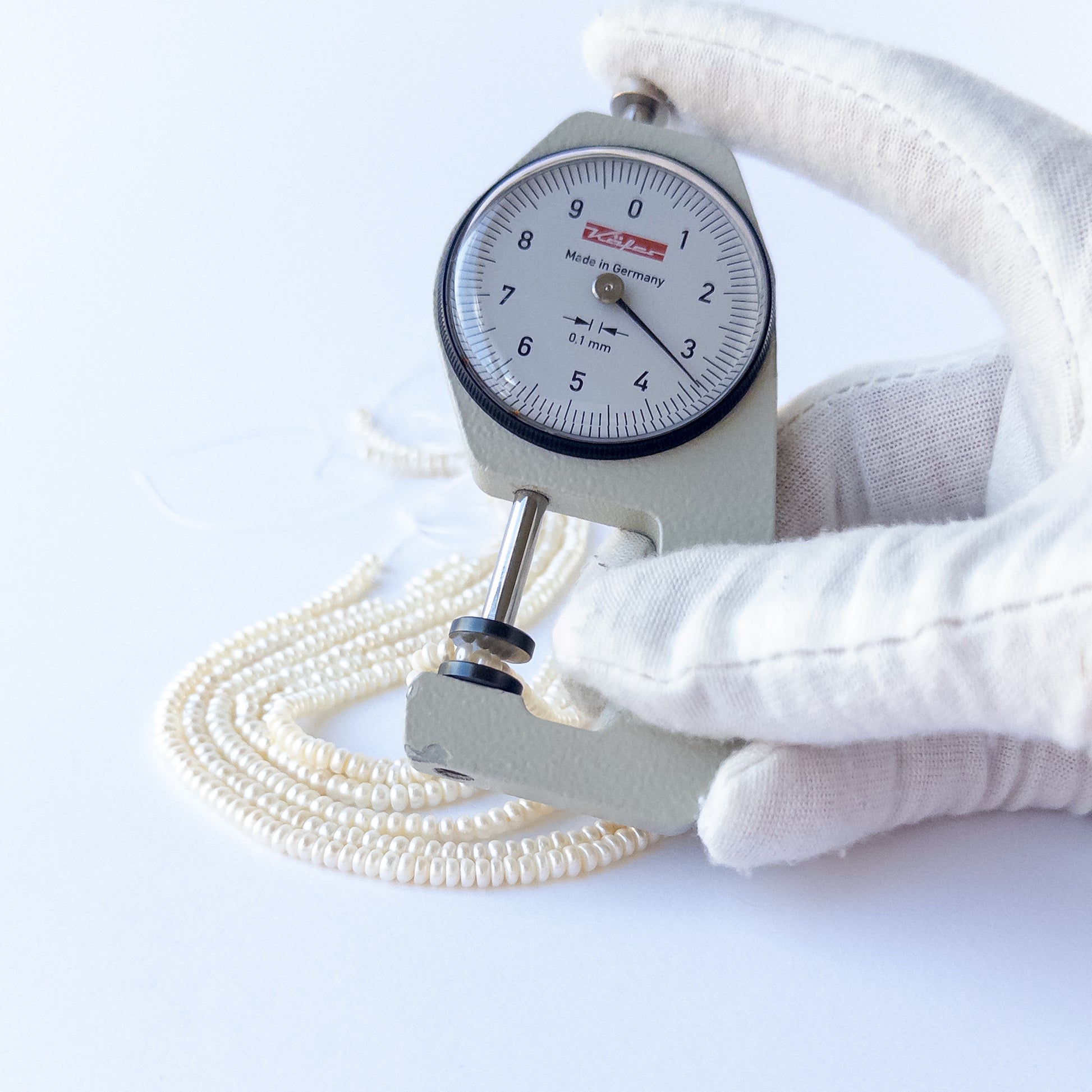 A dial gauge measures the Freshwater Pearls rondelle 3.1–3.5mm gemstone.