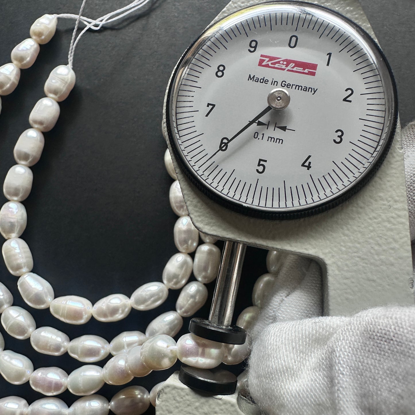 A dial gauge measures the Freshwater Pearls smooth  gemstone.