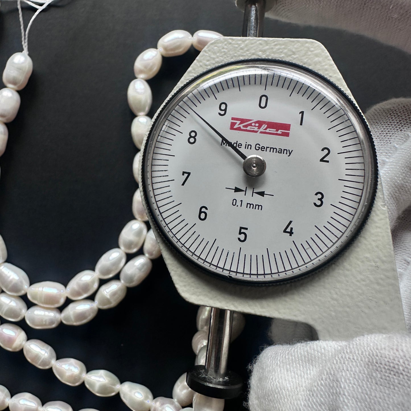 A dial gauge measures the Freshwater Pearls smooth  gemstone.
