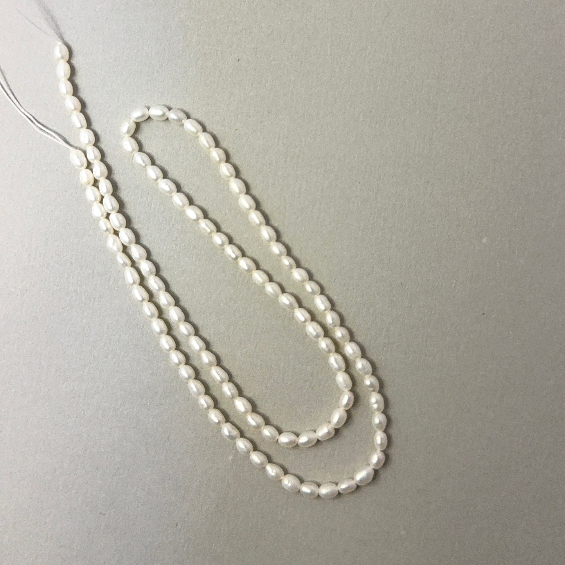 Lustrous Freshwater Pearl rice‑shaped beads with gentle shine, perfect for genuine gemstone beads in elegant designs.