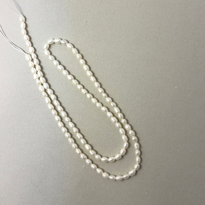 Lustrous Freshwater Pearl rice‑shaped beads with gentle shine, perfect for genuine gemstone beads in elegant designs.