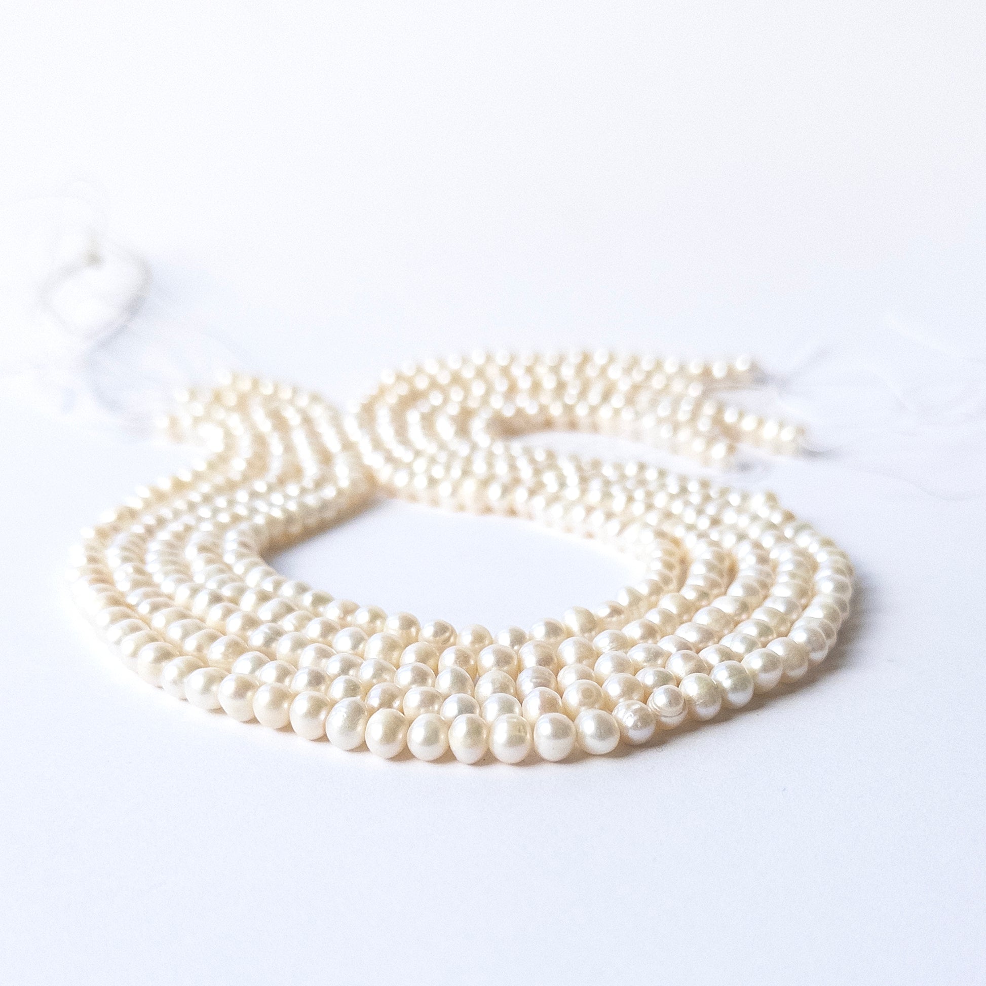 Freshwater Pearl smooth rondelle beads arranged in a strand showing soft white lustre and elegant shine.
