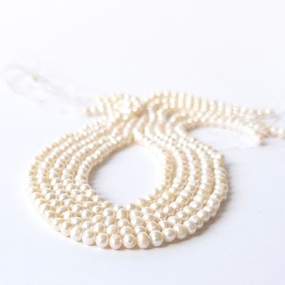 Close‑up of genuine Freshwater Pearl rondelle stone beads with polished surfaces and consistent 5.5–6mm size.