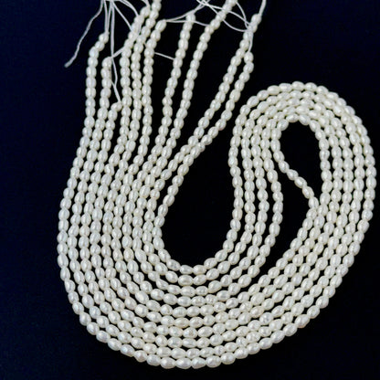 Freshwater rice pearls displayed on a strand to highlight their delicate oval shape and bright glow.