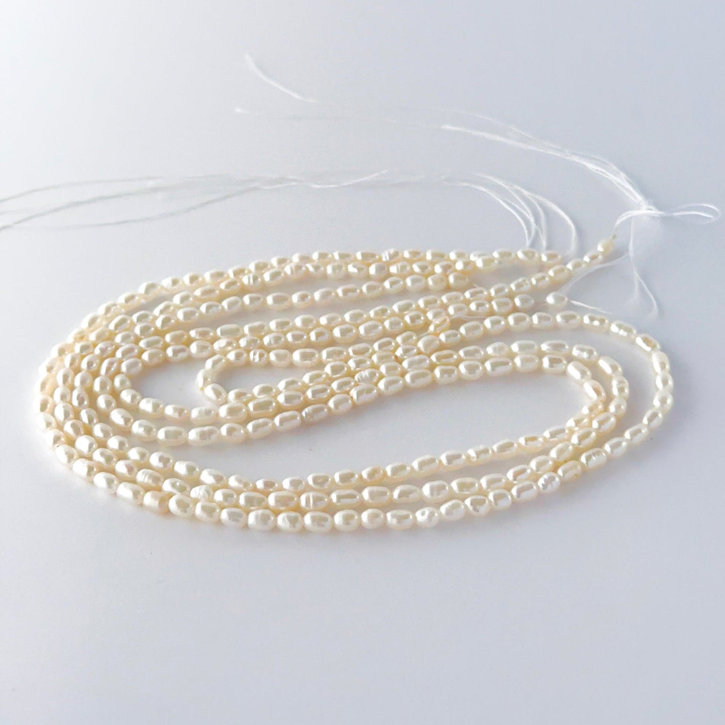 Small freshwater rice pearls arranged neatly, highlighting their smooth finish and handmade jewellery component quality.