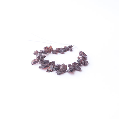 Authentic Garnet rough stone beads arranged to highlight their earthy colour and organic crystal texture.