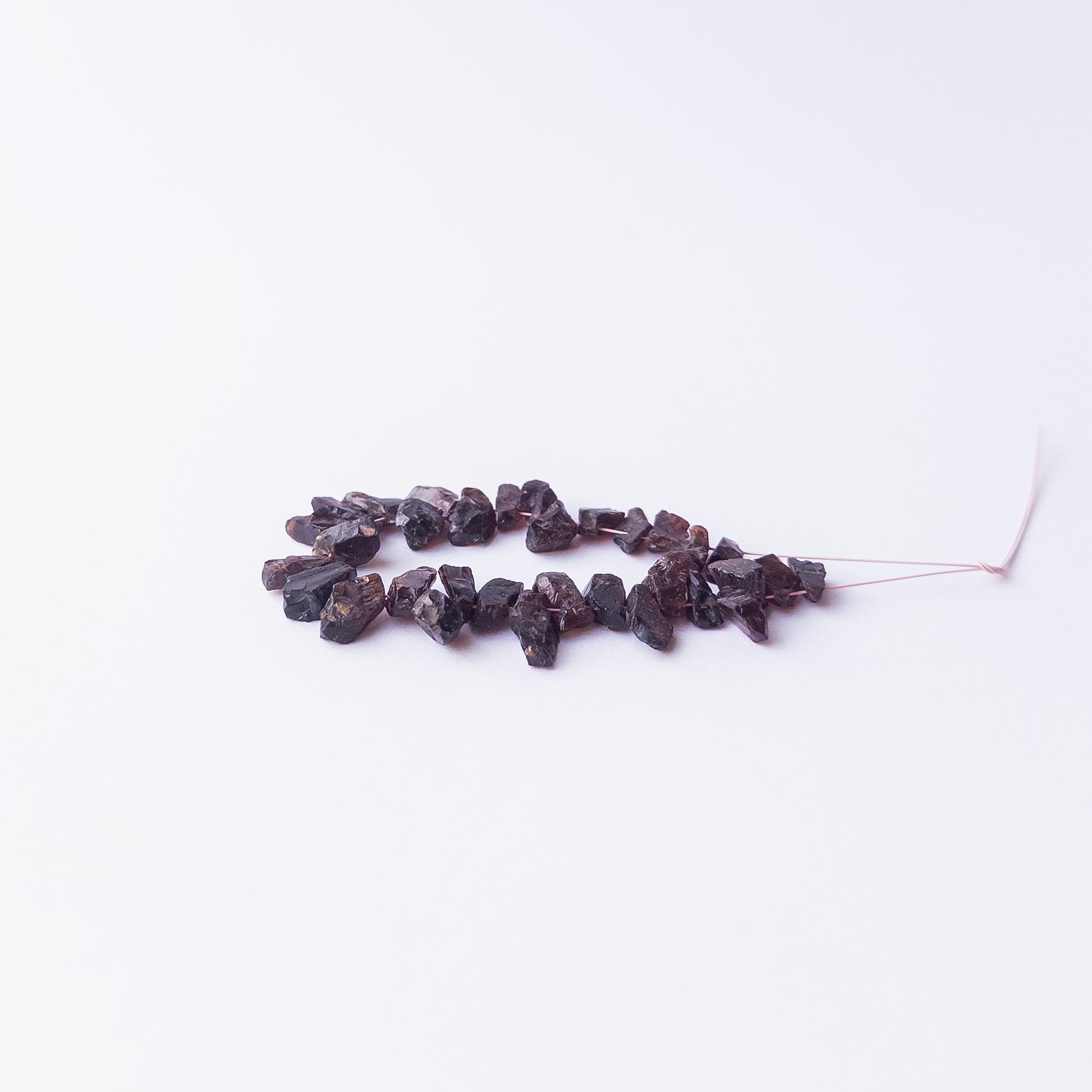 Authentic Garnet rough stone beads arranged to highlight their earthy colour and organic form.