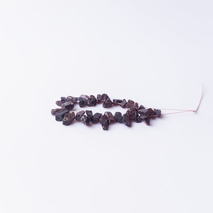 Authentic Garnet rough stone beads arranged to highlight their earthy colour and organic form.