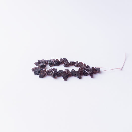 Authentic Garnet rough stone beads arranged to highlight their earthy colour and organic form.