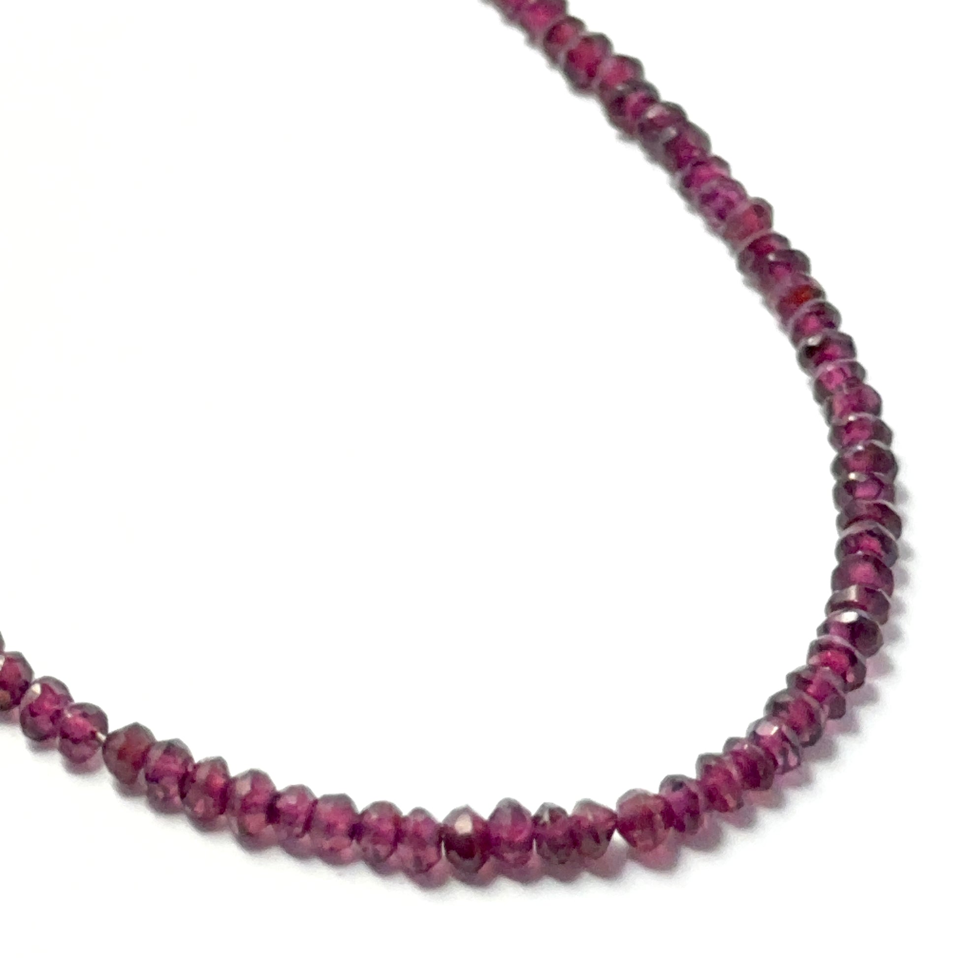Garnet faceted rondelle beads with a glossy finish, arranged neatly on a strand for gemstone bead jewellery projects.