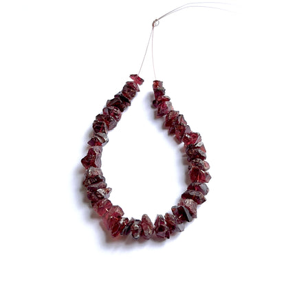 Garnet rough beads photographed to show their unpolished finish and suitability for handmade jewellery components.