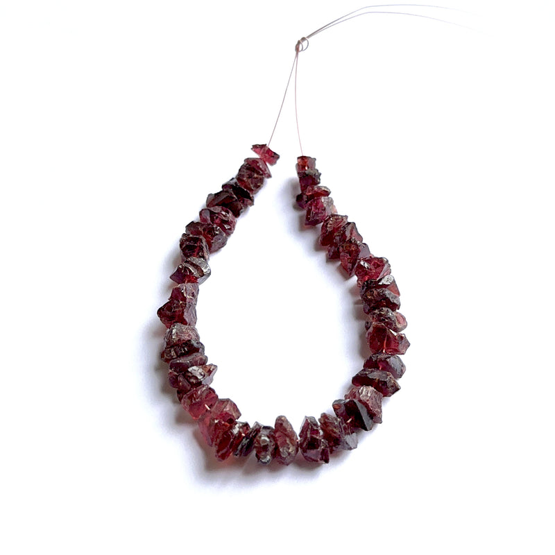 Garnet rough beads photographed to show their unpolished finish and suitability for handmade jewellery components.