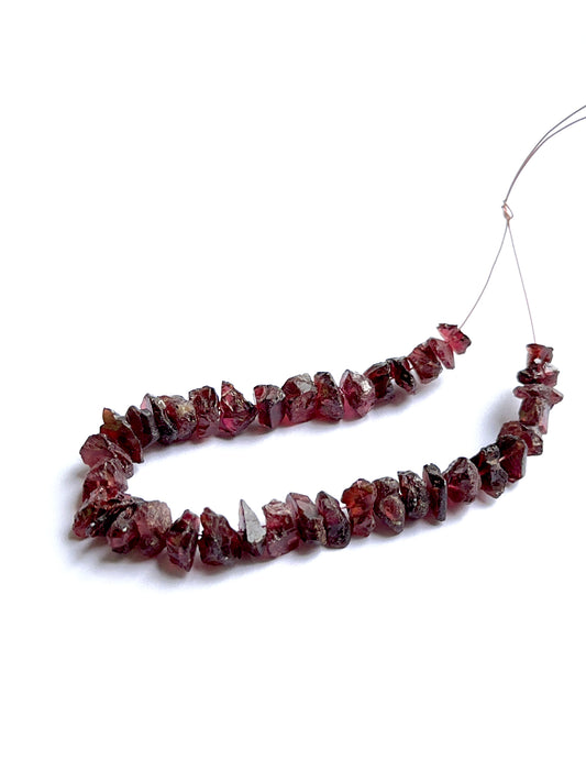 Raw garnet stones displayed with visible texture ideal for natural gemstone beads in jewellery making.