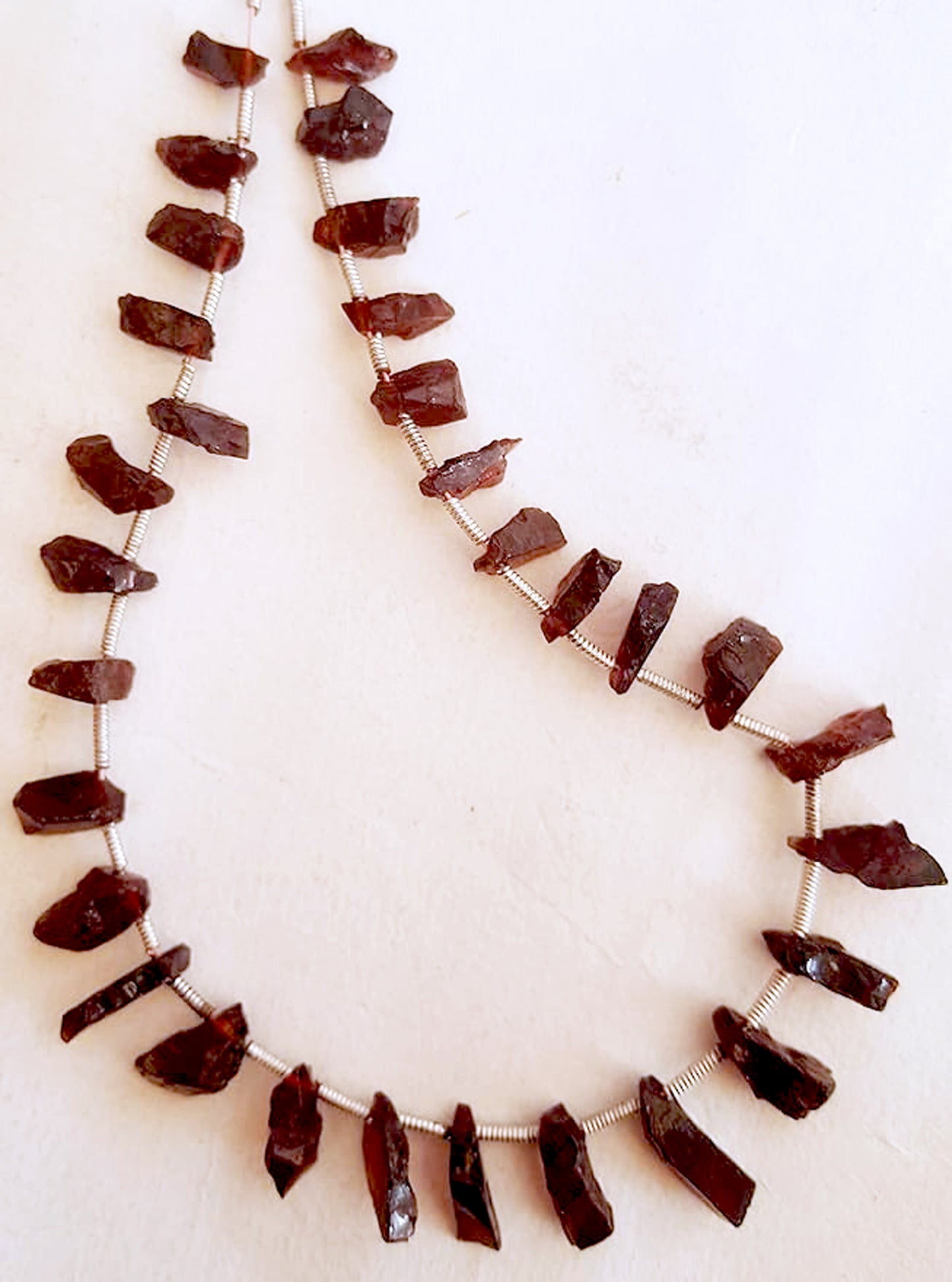 Close-up of 31 garnet stones with irregular cuts, highlighting their rich hue and organic sparkle.