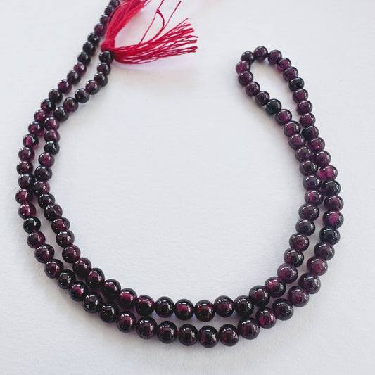 Close-up of Garnet smooth round beads with deep red tones and polished finish.