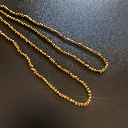 Detailed view of gold pyrite rondelle beads with shimmering golden tones and clarity.