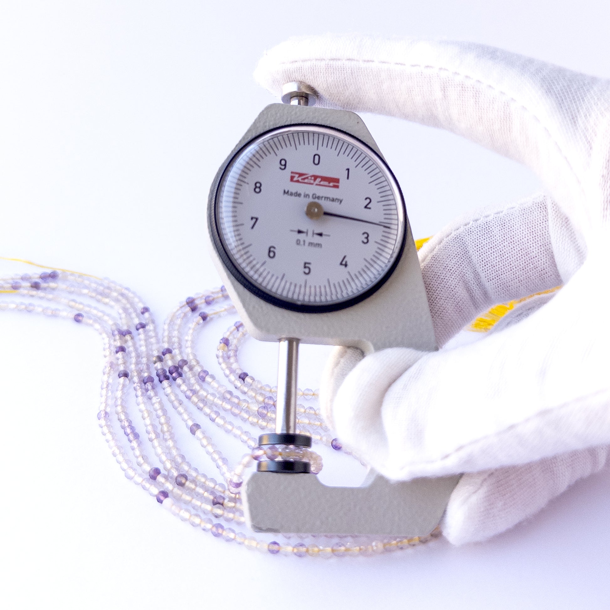A dial gauge measures the Golden Rutile faceted rondelle 2.6mm gemstone.