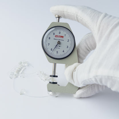 A dial gauge measures the Green Amethyst Faceted Briolette 6-10mm gemstone.