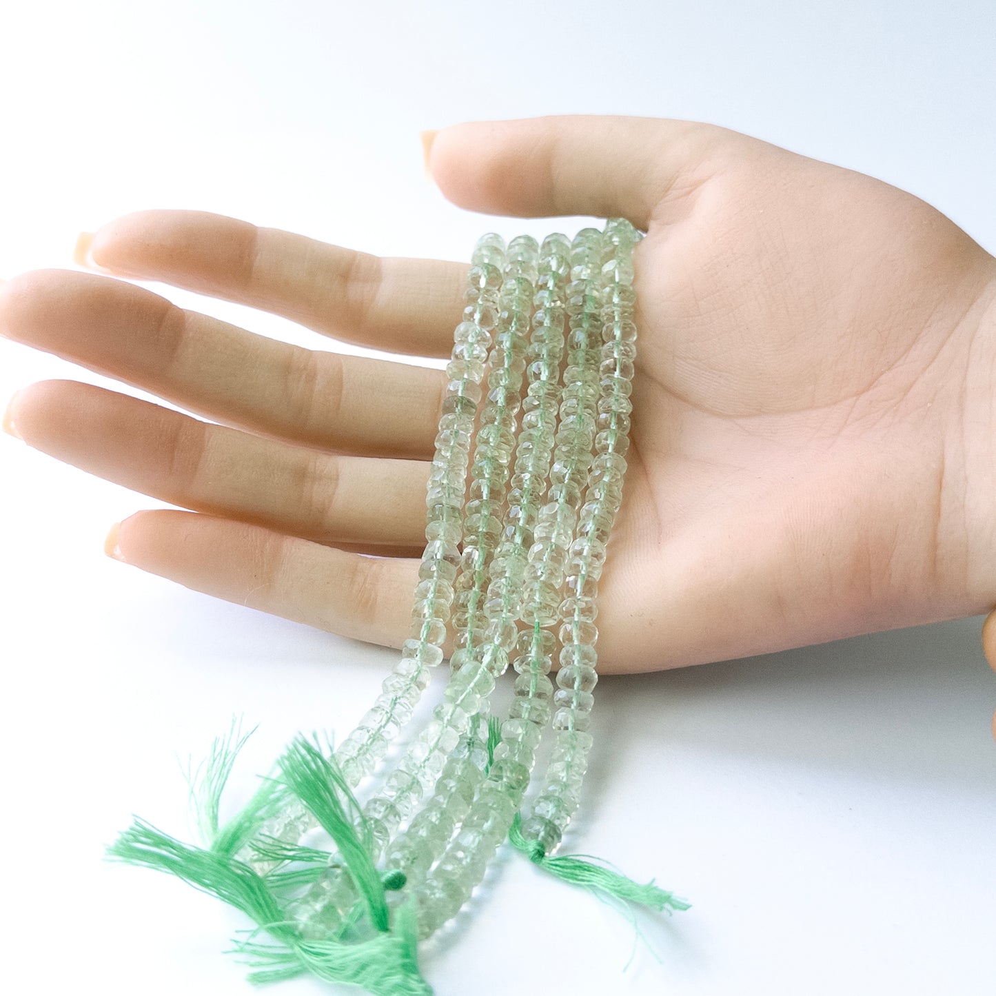 Genuine Green Amethyst gemstone beads displaying soft green tones, polished facets, and a neatly arranged 16cm strand for jewellery design.