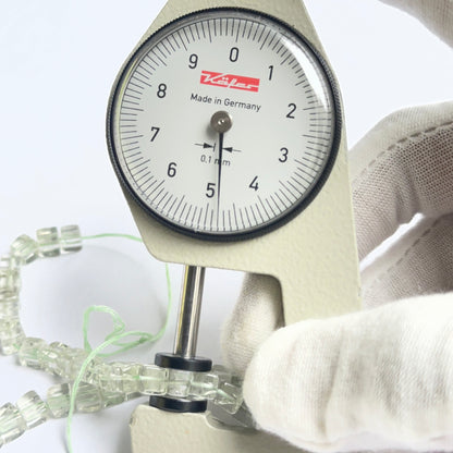 A dial gauge measures the green amethyst smooth cube 4.5–5mm gemstone.