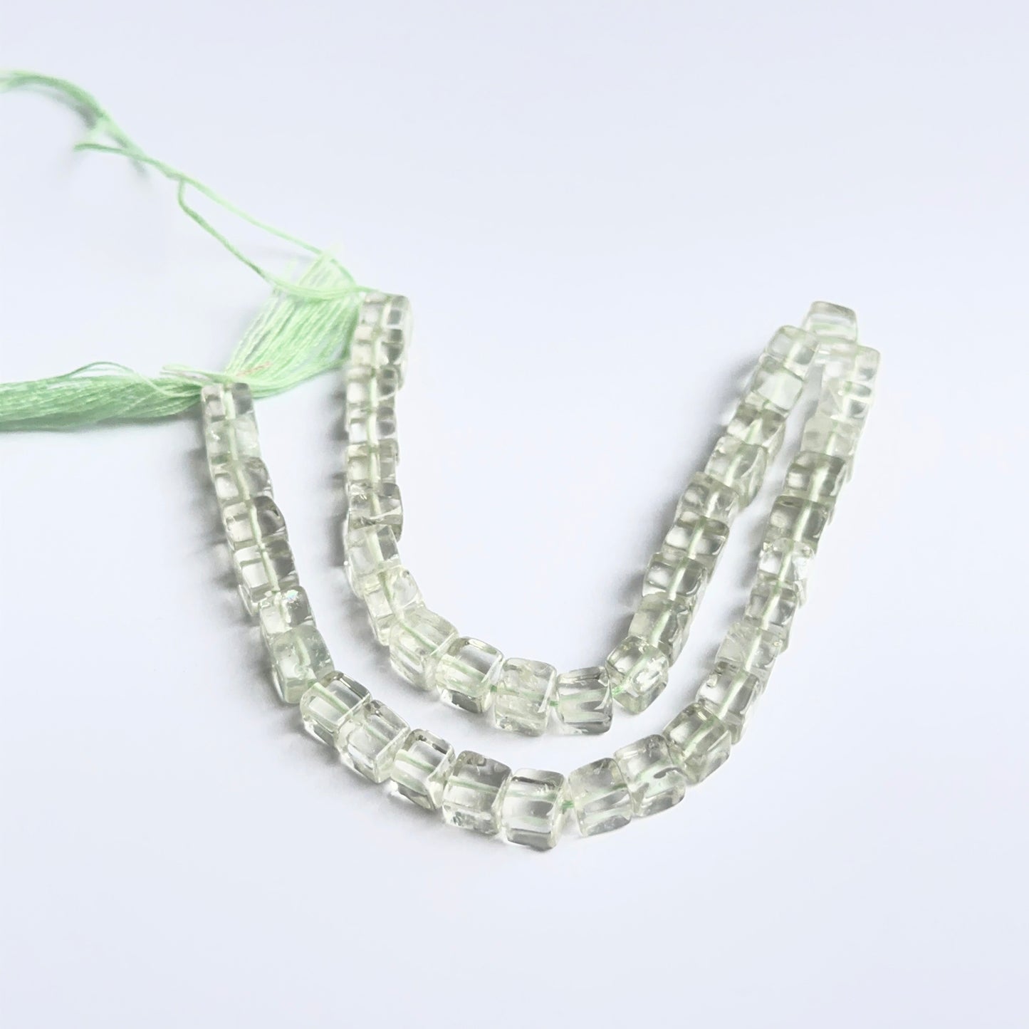 Green amethyst cube beads arranged neatly to showcase uniform shape, colour and gemstone quality.
