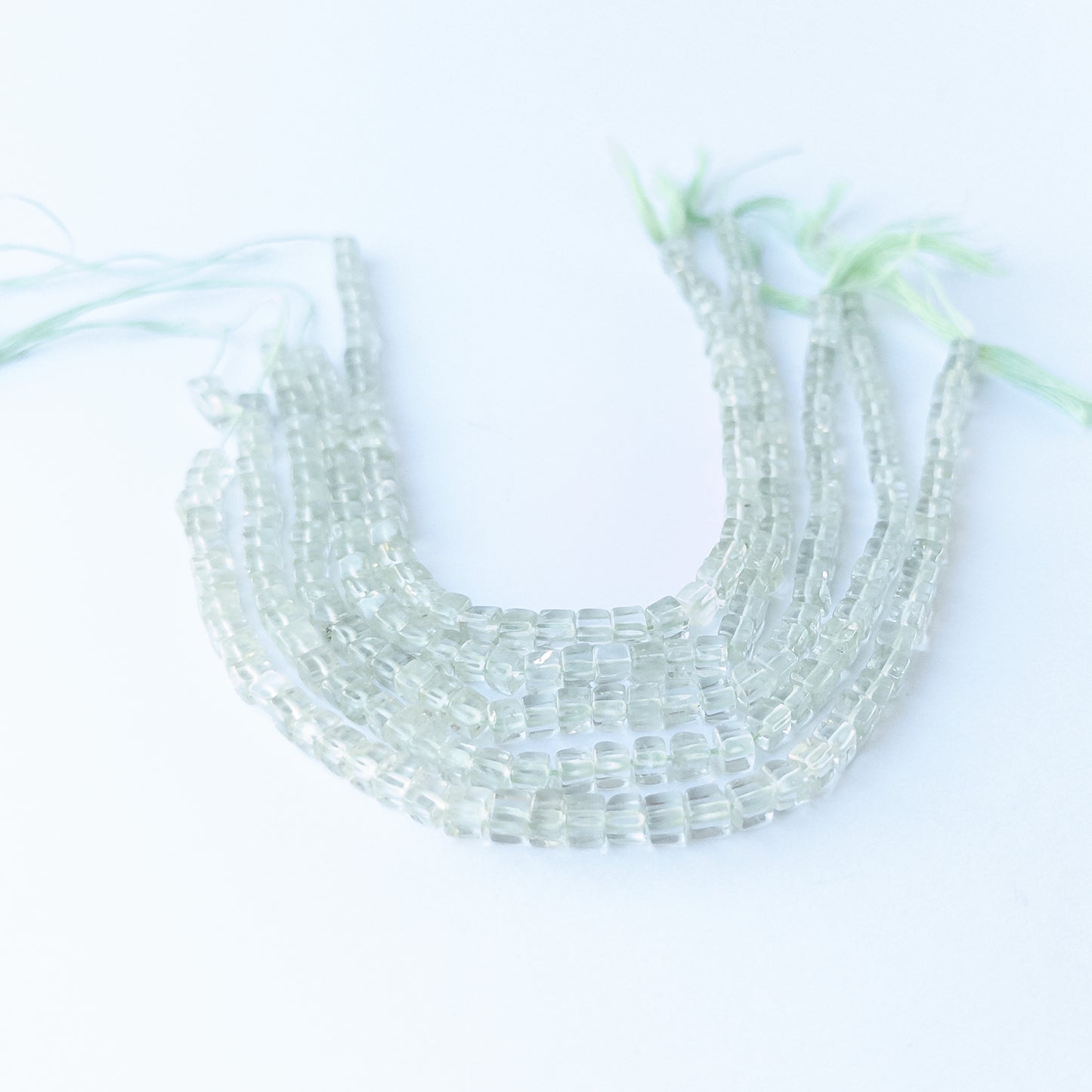 Close‑up of genuine Green Amethyst smooth cube beads highlighting their clarity, shine and precise cube cut.