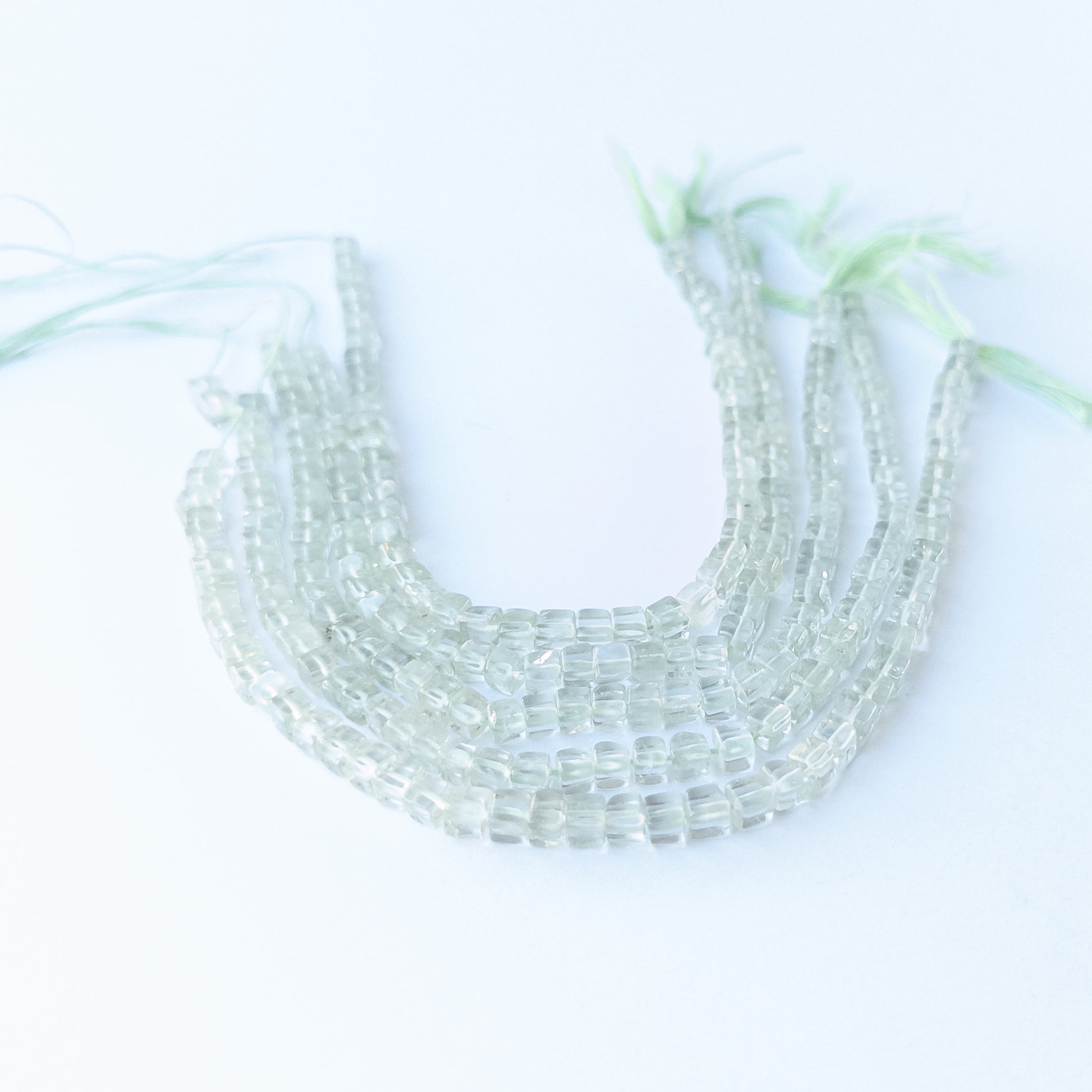 Close‑up of genuine Green Amethyst smooth cube beads highlighting their clarity, shine and precise cube cut.