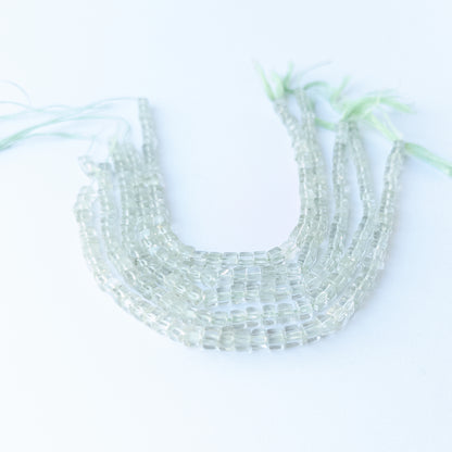 Close‑up of genuine Green Amethyst smooth cube beads highlighting their clarity, shine and precise cube cut.