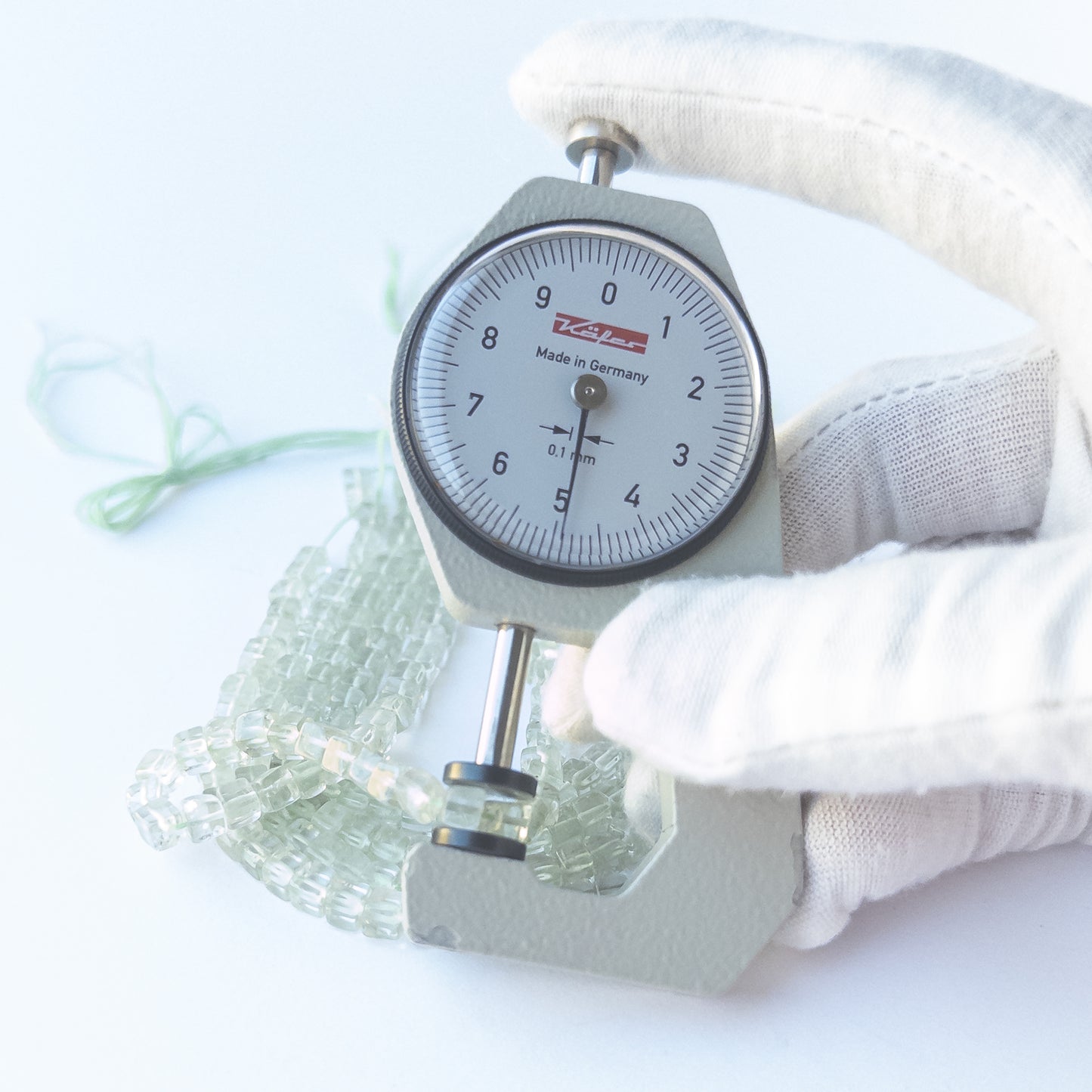 A dial gauge measures the Green Amethyst smooth cube 4.2–4.5mm gemstone.