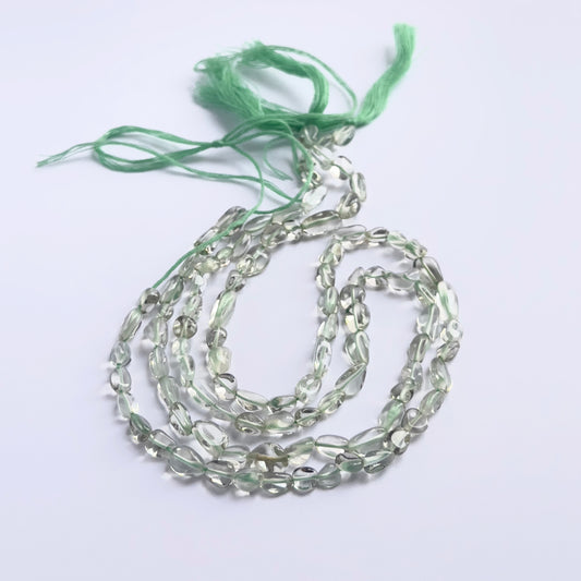 Stone beads in a strand of Green Amethyst, highlighting their smooth tumbles and 5–6mm size.