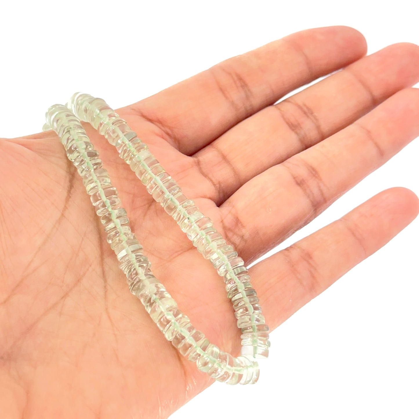 Hand holds Pale green prasiolite smooth wheel beads, 6.5–7.0mm, displayed on a 21cm strand.