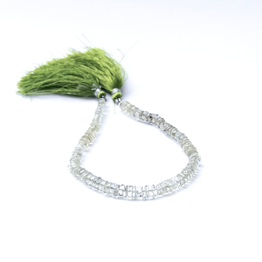 Green Amethyst smooth wheel beads arranged in a strand showing soft green tones and polished surfaces.