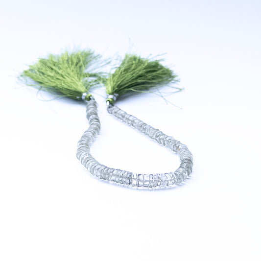 Green Amethyst smooth wheel beads arranged in a strand showing soft green tones and polished surfaces.