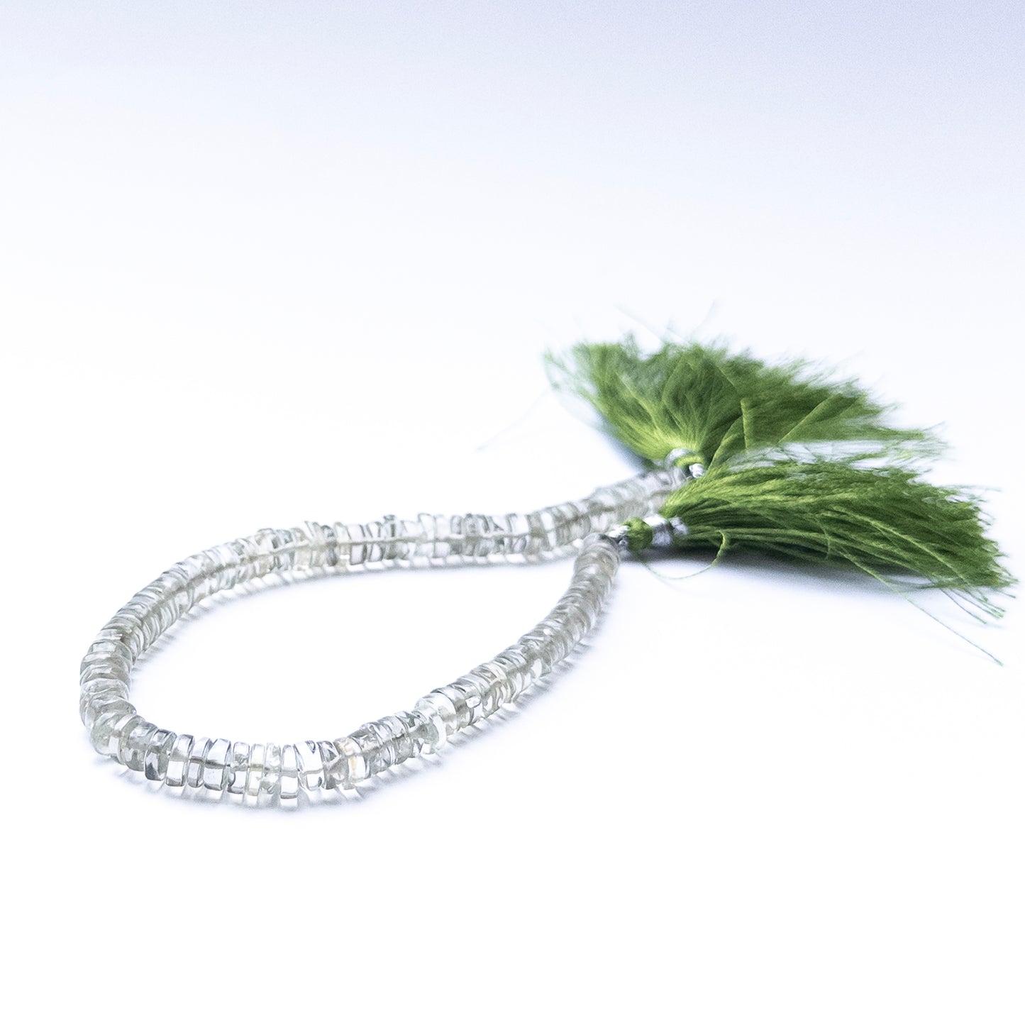 Smooth wheel‑cut Green Amethyst beads showing soft glow and refined cutting.