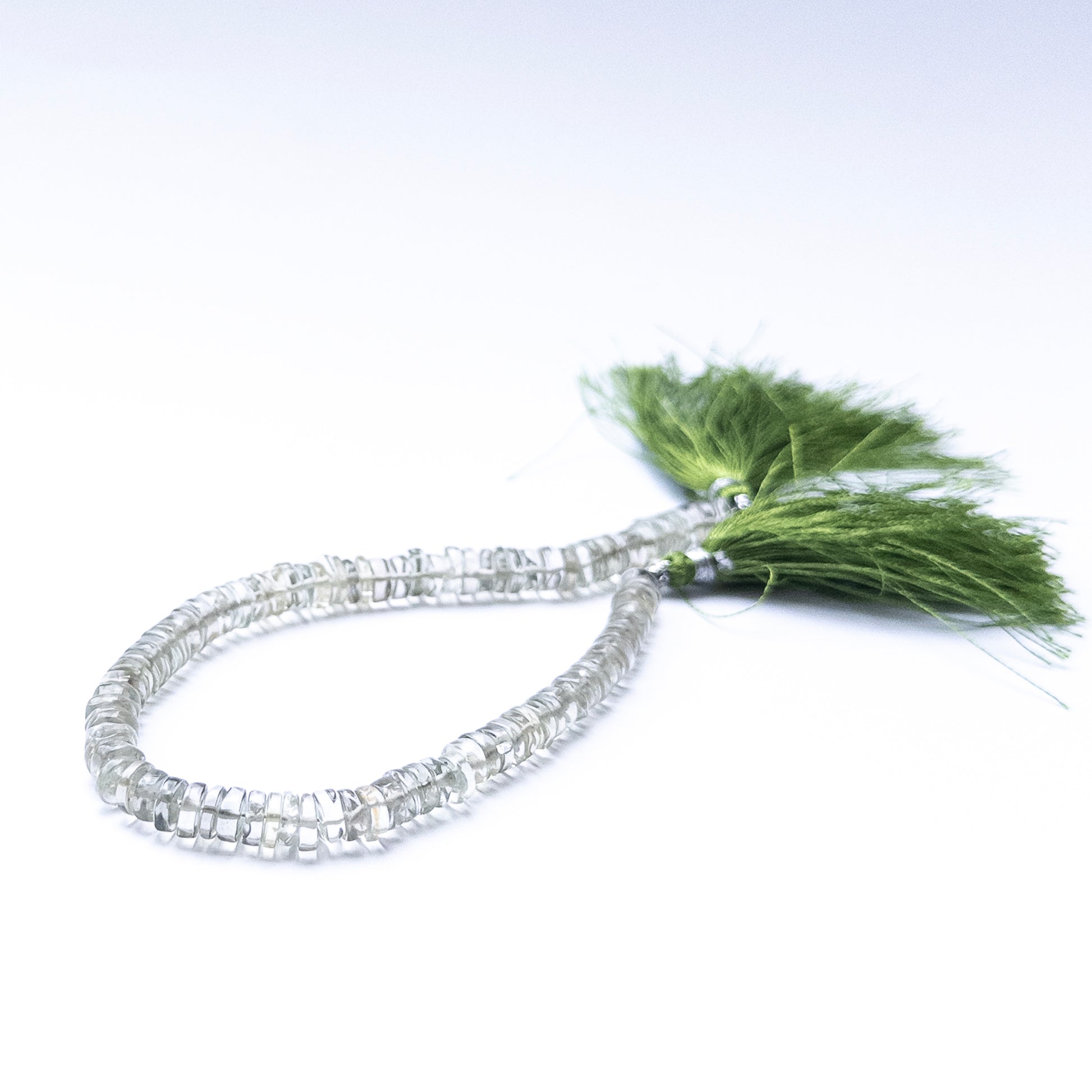 Smooth wheel‑cut Green Amethyst beads showing soft glow and refined cutting.